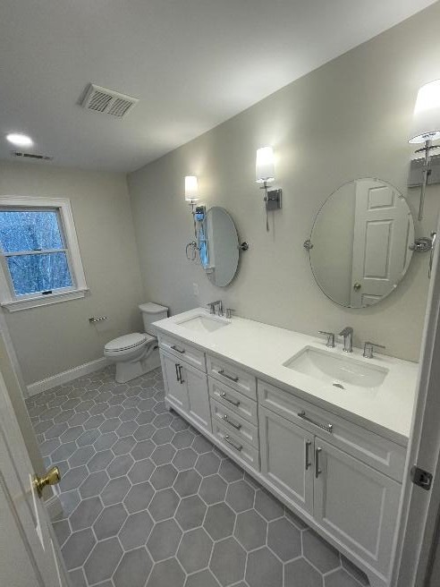 Bathroom with gray hexagonal floor tile and a double vanity
