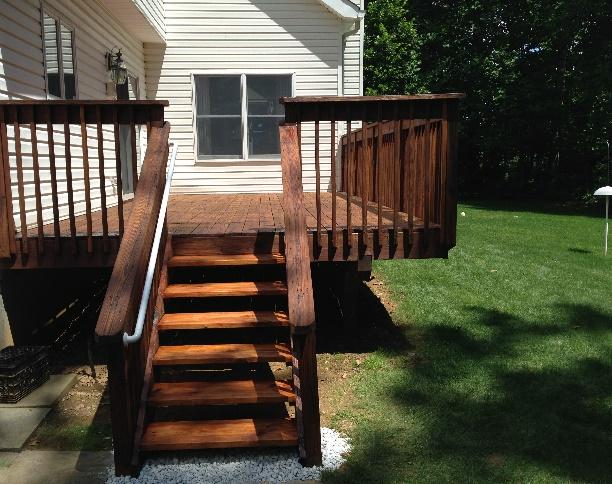 Stained wood deck and stairs off the back of a house